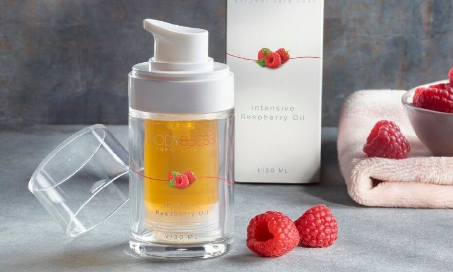 Intensive Raspberry Oil met frambozen op de achtergrond.